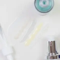 Kwas szikimowy w kosmetykach: próbki serum i pipeta na białym tle.